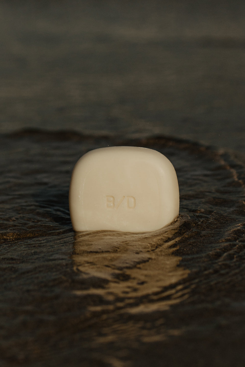 A beauty disrupted luxury solid shampoo in shallow water