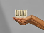 Handcrafted ceramic mini TRIO travel holder displaying solid shampoo, conditioner, and body bars.